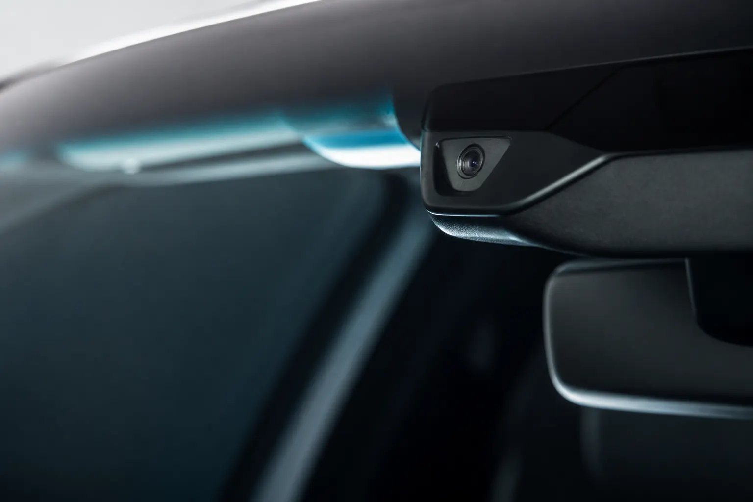 Sensor y cámara de seguridad discretamente integrados en el interior de un vehículo premium.