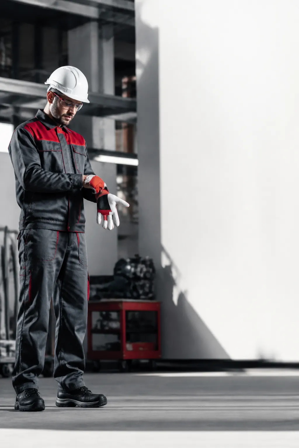 Trabajador industrial ajustándose los guantes antes de comenzar su jornada.