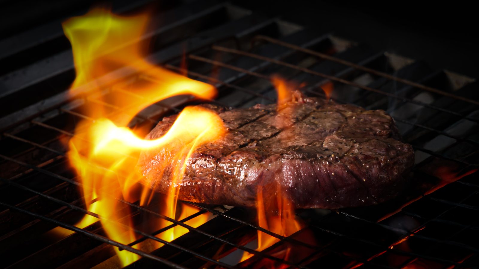 Bife sobre la parrilla con llamarada