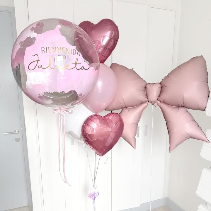 Globos de bienvenida rosados con burbuja, corazones y un gran lazo