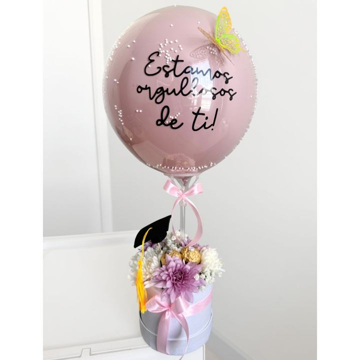 Globo rosado Estamos orgullosos de ti, con flores y gorro de graduación