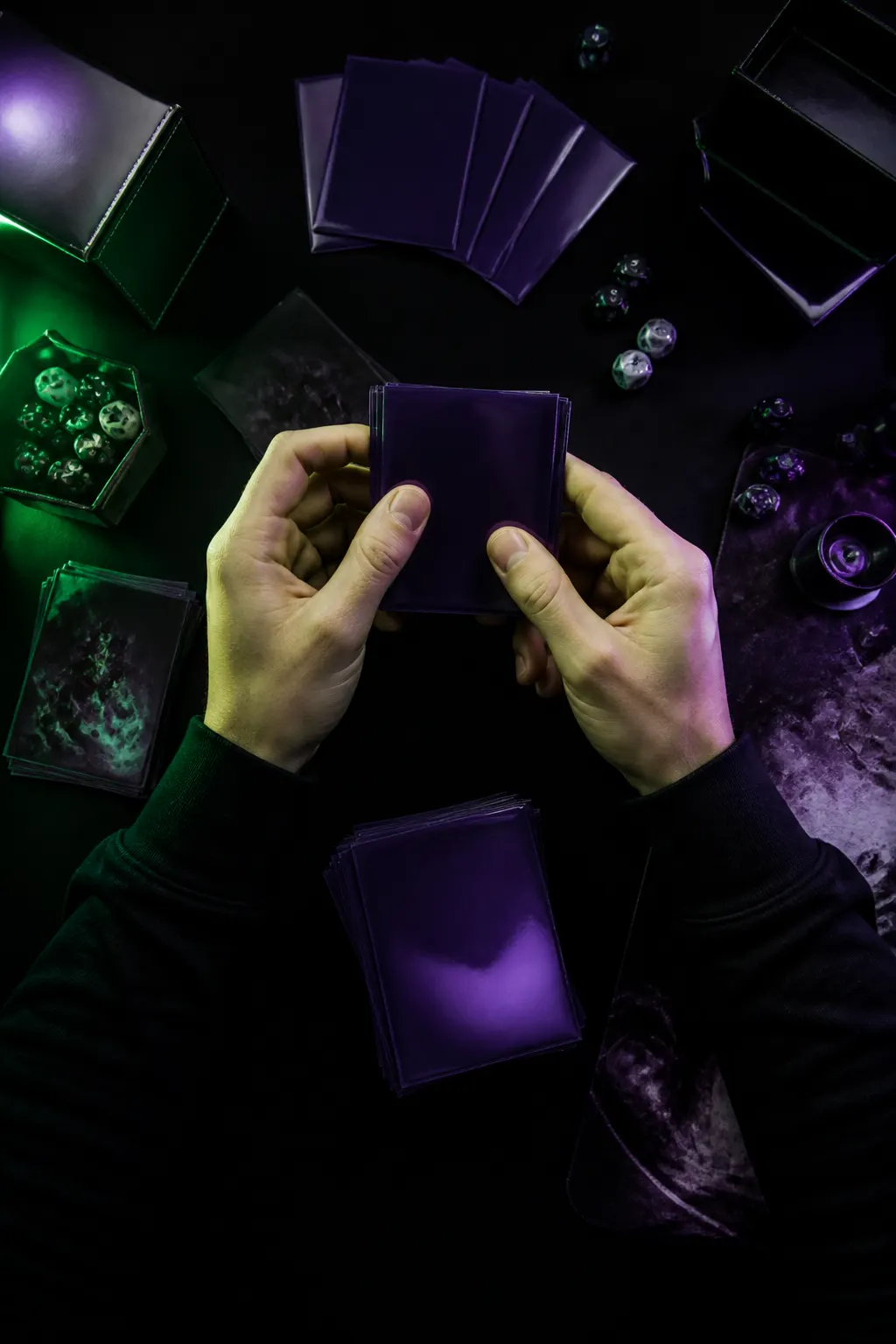 Manos organizando cartas TCG enfundadas para construir un mazo sobre una mesa negra.