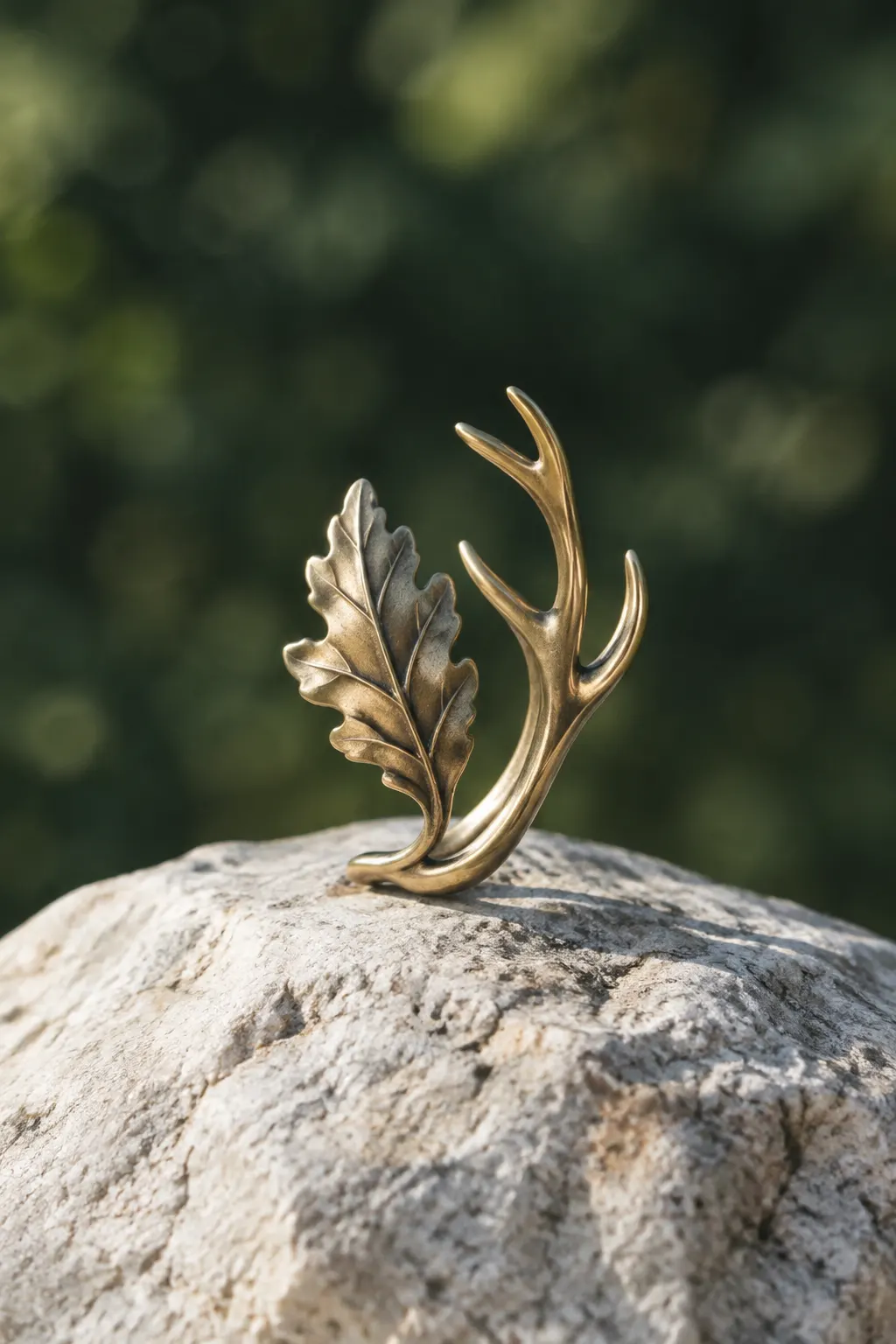 Joya metálica de diseño inspirado en la naturaleza sobre una piedra clara.
