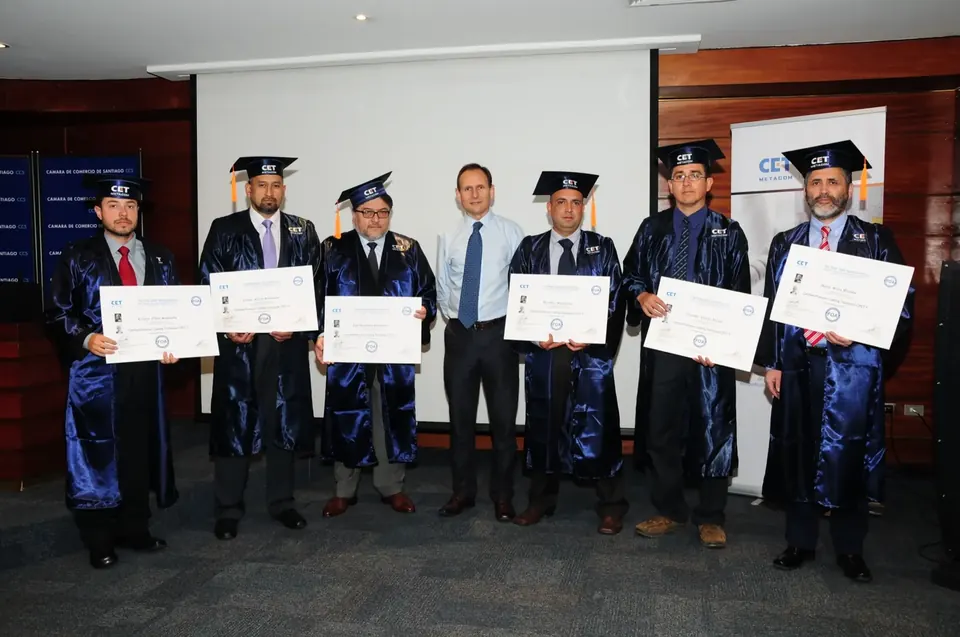 Graduados de CET Metacom con toga y birrete muestran sus certificados FOA.