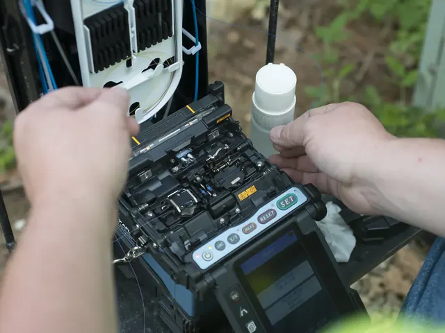 Manos de un técnico ubican la fibra en una fusionadora.