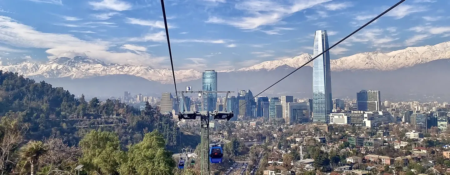 Santiago desde el teleférico del cerro San Cristóbal: cables, cabinas, rascacielos y la cordillera nevada.
