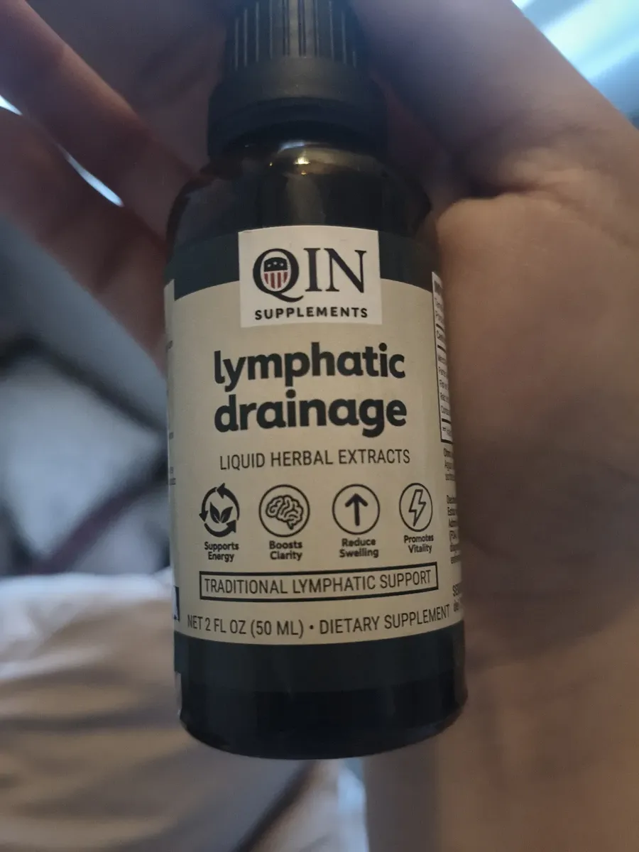 Frasco de QIN Lymphatic Drainage sostenido en la mano
