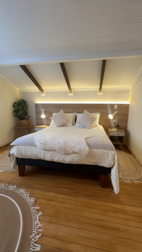 Video de un dormitorio con vigas y luz cálida