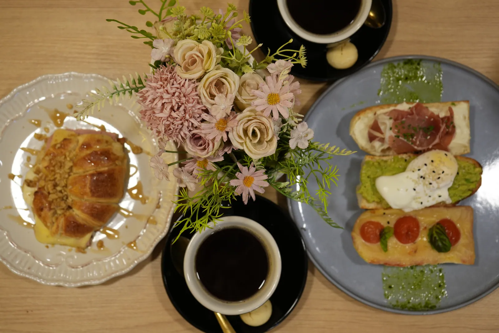 Mesa del Lounge con croissant, tostadas, café y flores