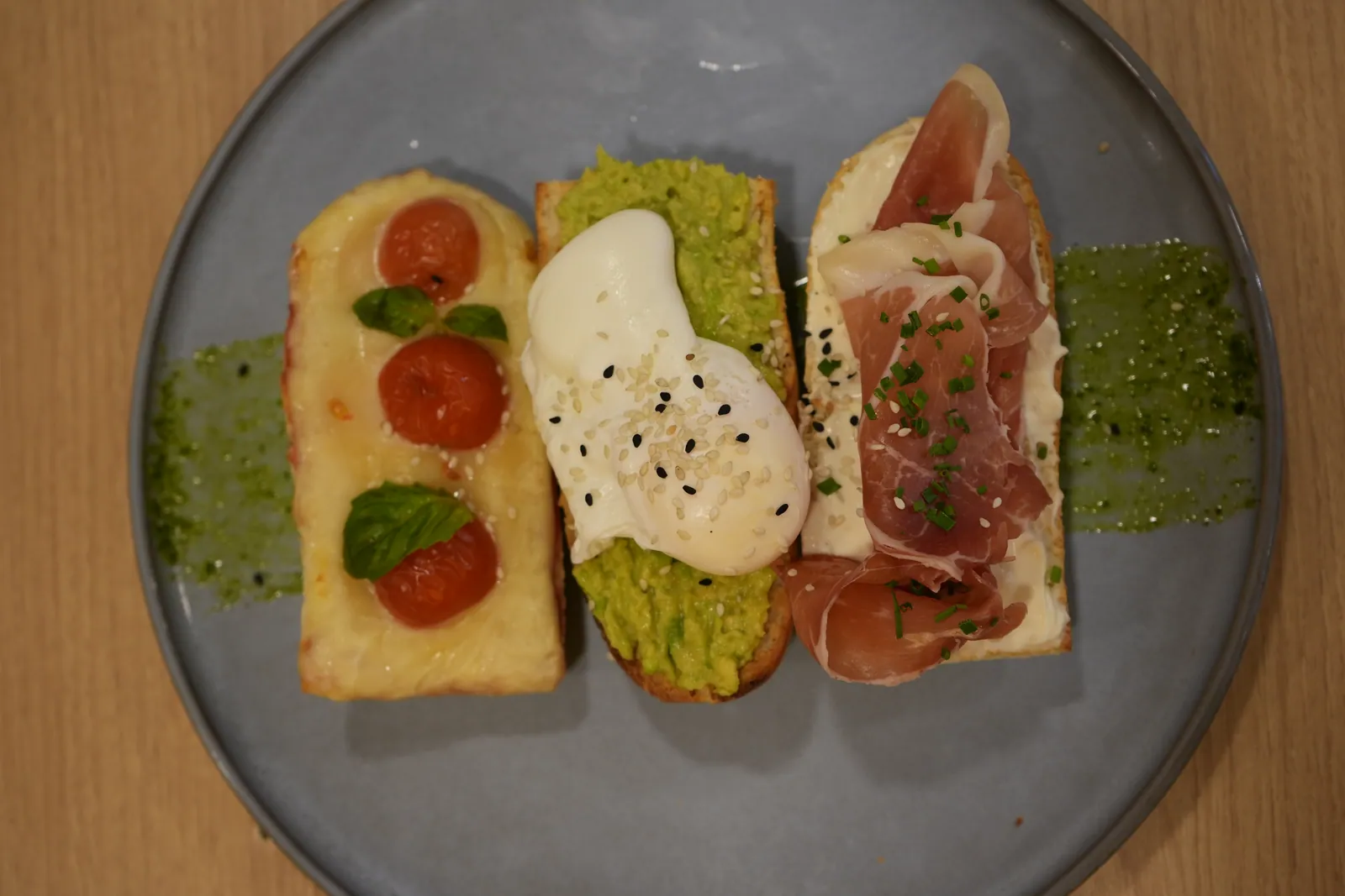 Tres tostadas con tomates cherry, palta con huevo y jamón serrano