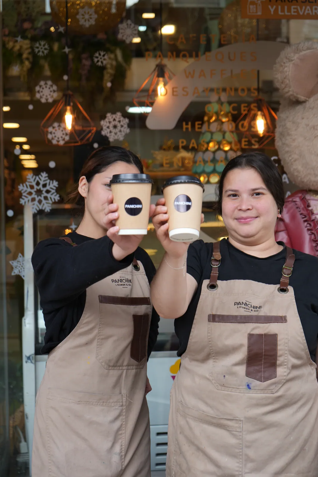 Dos integrantes del equipo brindan con vasos de café Panichini