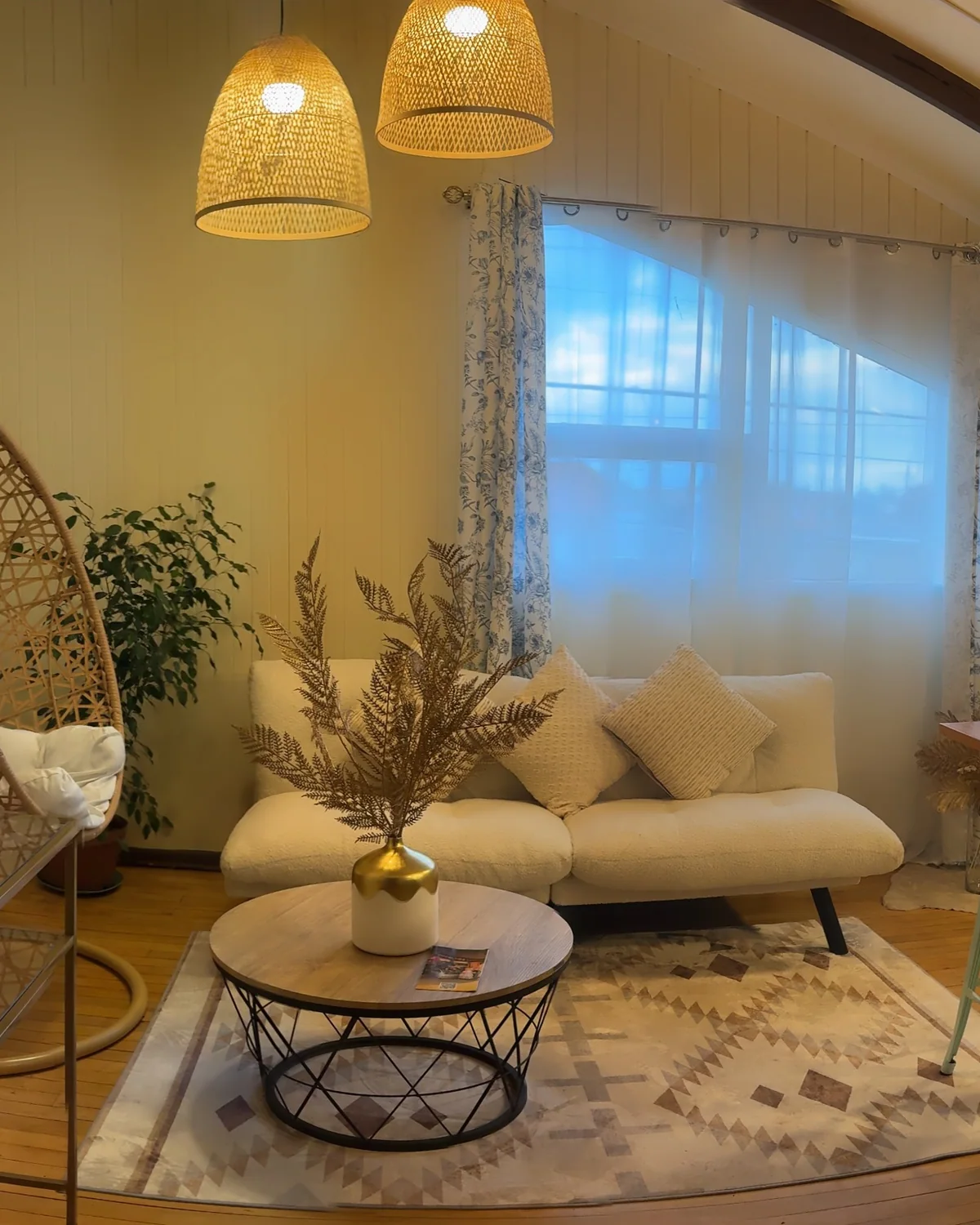 Sala de estar de Casona Panichini con lámparas de ratán, sofá blanco y una gran ventana