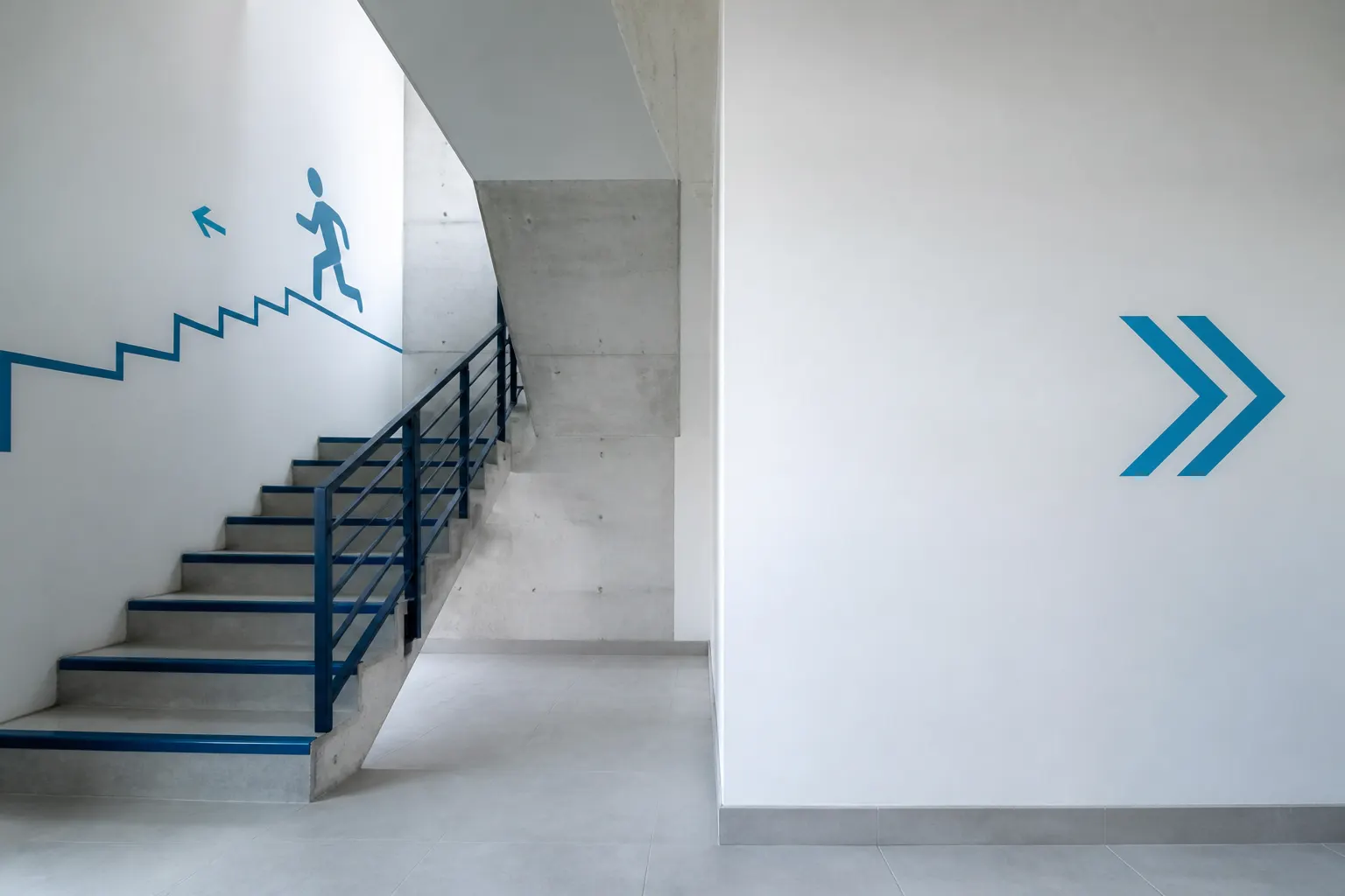 Escalera limpia de condominio con una ruta de evacuación despejada.