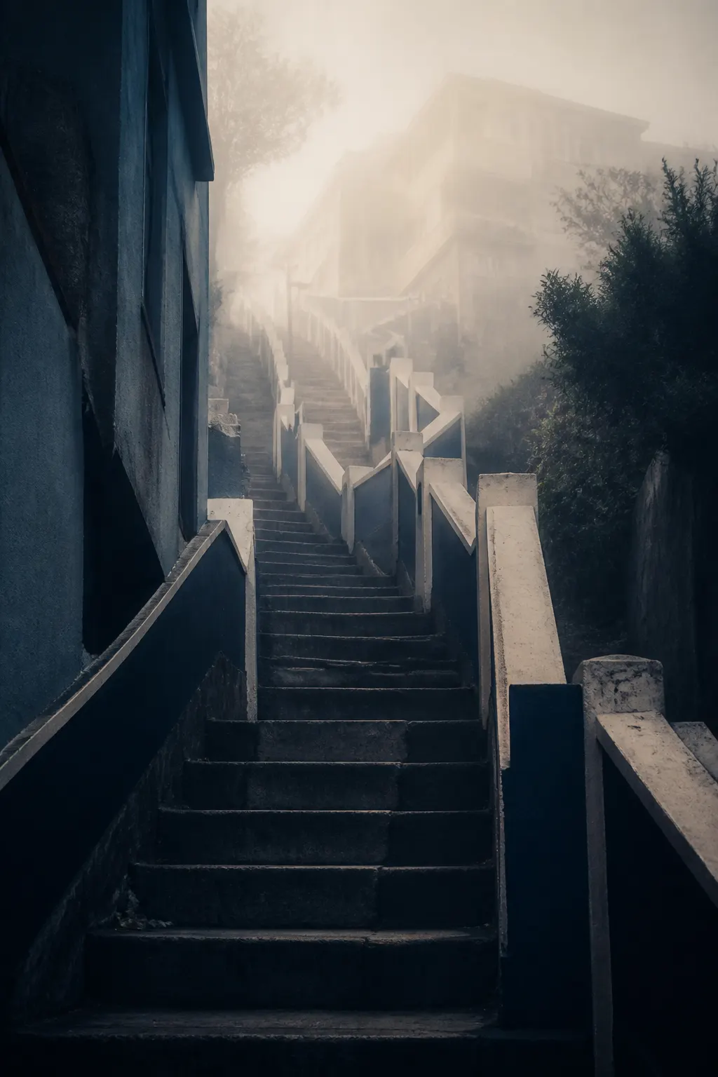 Escalera de hormigón y desnivel portuario cubiertos por niebla azulada.