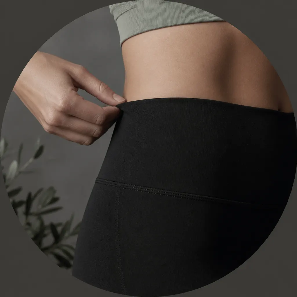 Mão ajustando a cintura de leggings pretas durante um movimento de treino suave.