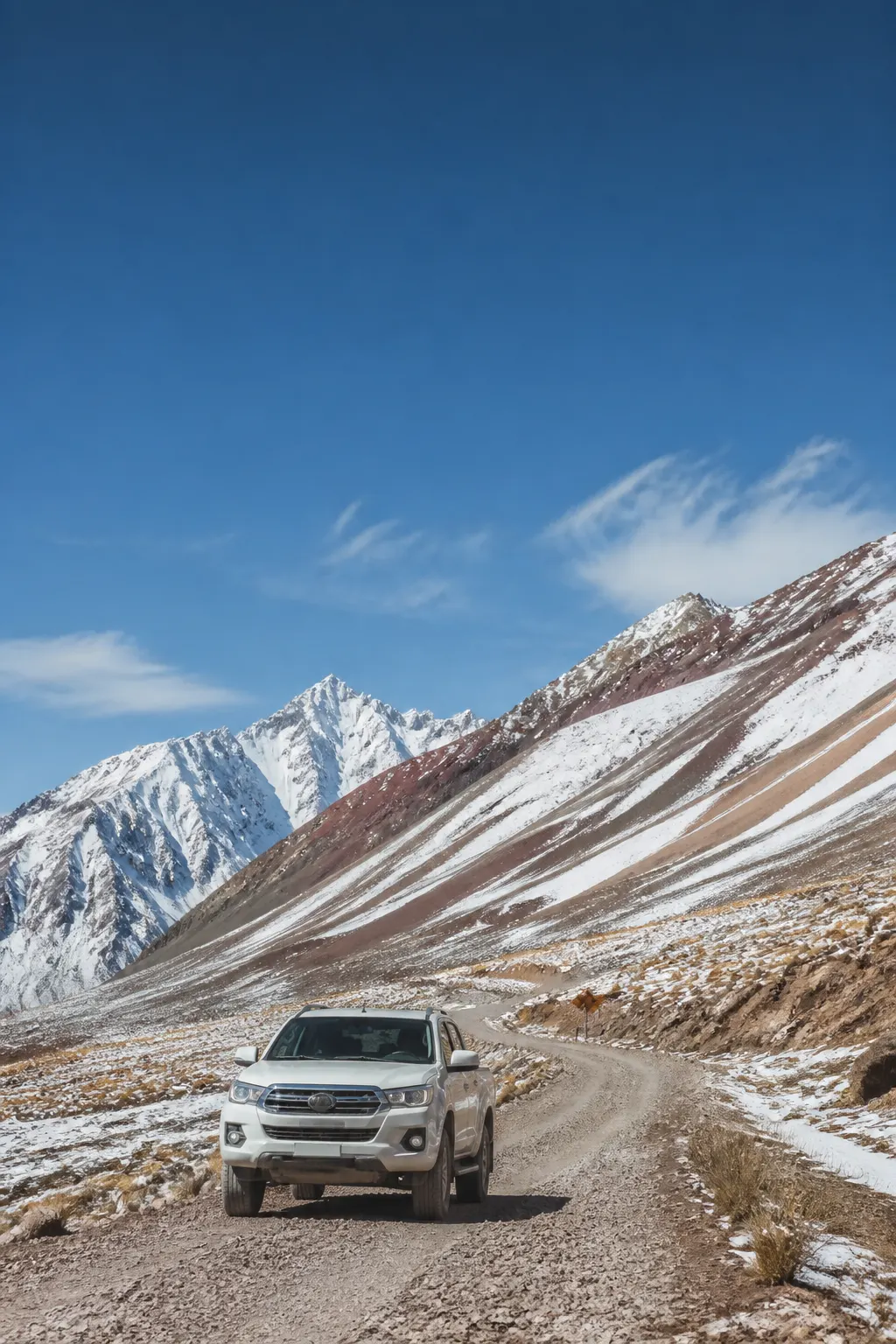 Camioneta 4x4 avanzando por un camino cordillerano del valle de Aconcagua bajo un cielo azul.