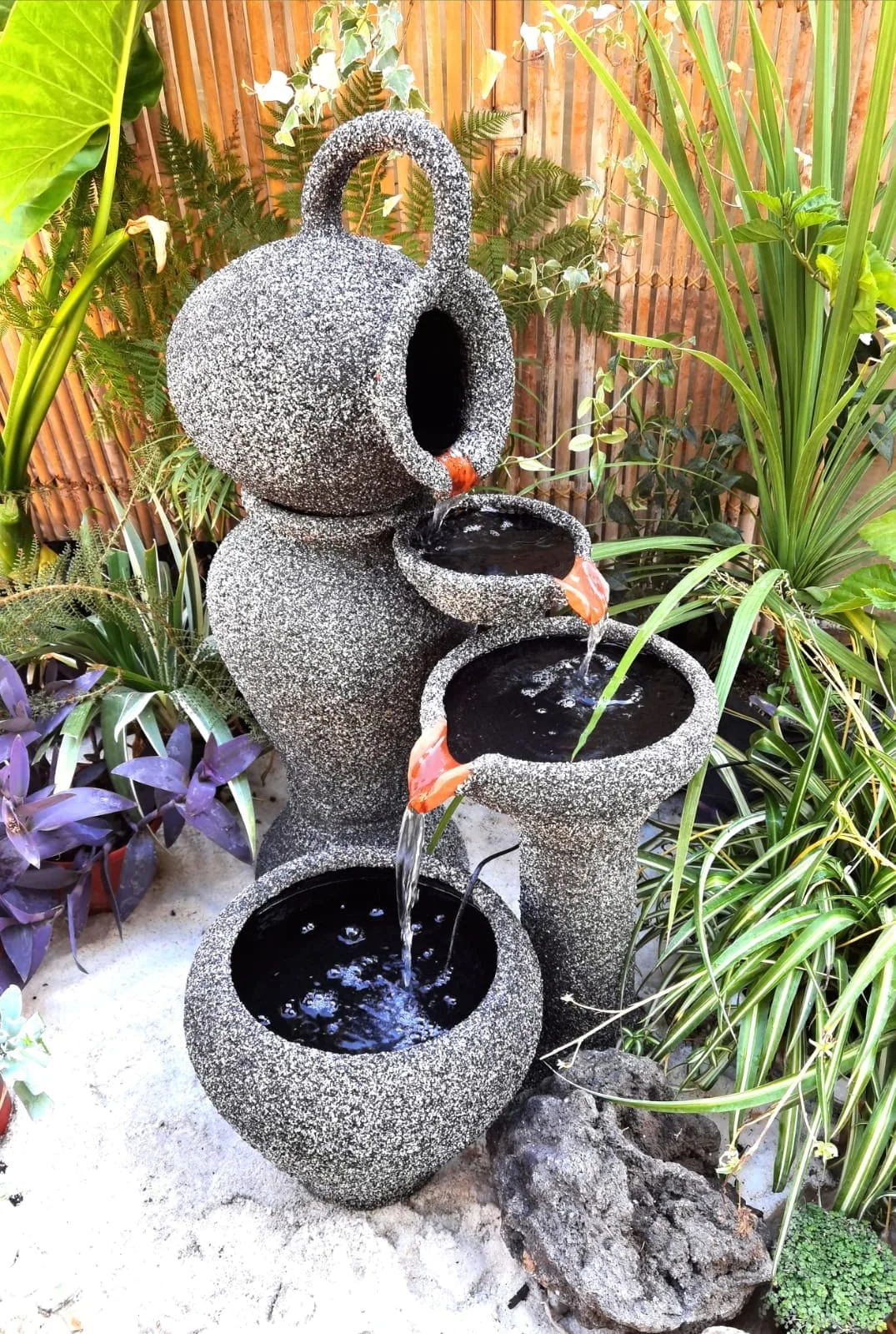 Fuente de agua con jarros de acabado gris y detalles de terracota