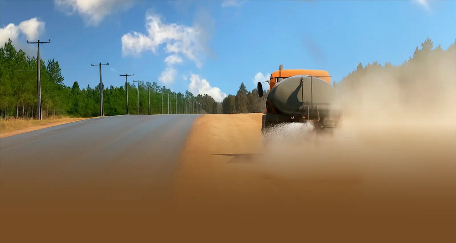 Camión naranja aplicando supresor de polvo en camino forestal para faenas industriales